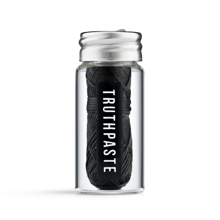 Close-up of Truthpaste charcoal-infused bamboo dental floss